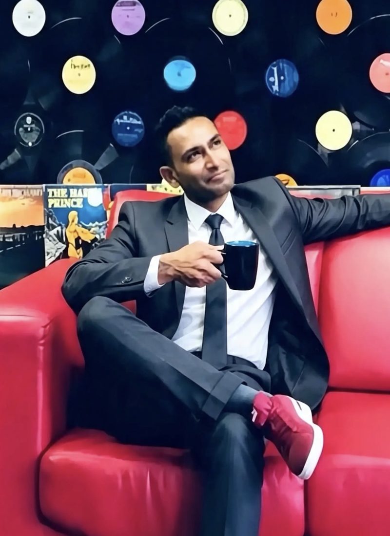 Marlin Chetty on a red sofa with coffee, vinyl records on the wall