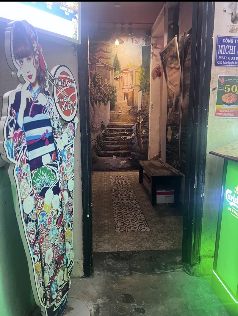A painted stairway mural at the end of a narrow tiled doorway on Nguyễn Huệ, Saigon
